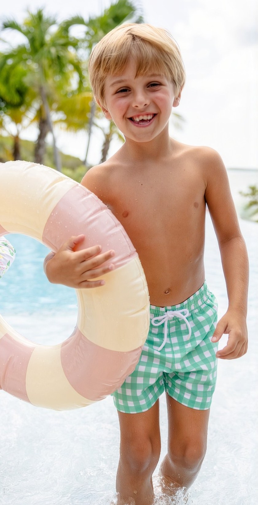 Boy in green gingham swim trunks with pool float